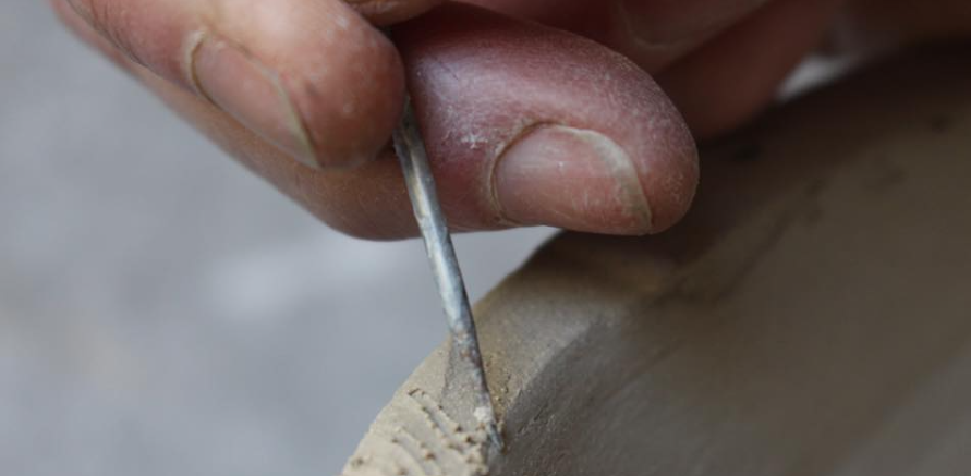 Détail d'un dessin décoratif sur une pièce en céramique RAKU, création artisanale de l’Atelier de la Terre Ronde.